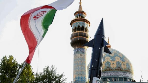 Des Iraniens brandissent un drapeau et la maquette d