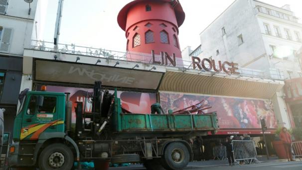 Des ouvriers sécurisent la zone devant le Moulin Rouge à Paris après que ses ailes et des lettres de la façade sont tombées dans la nuit sans faire de blessés, le 25 avril 2024