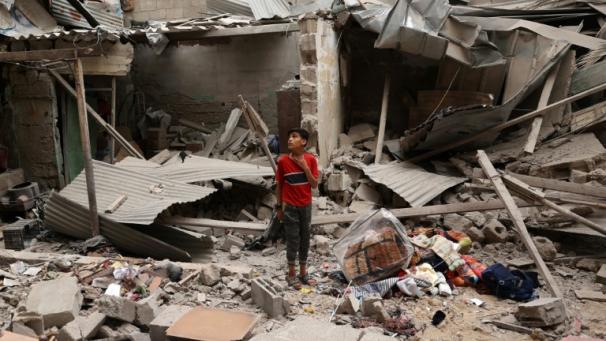Un enfant palestinien se tient parmi les débris d