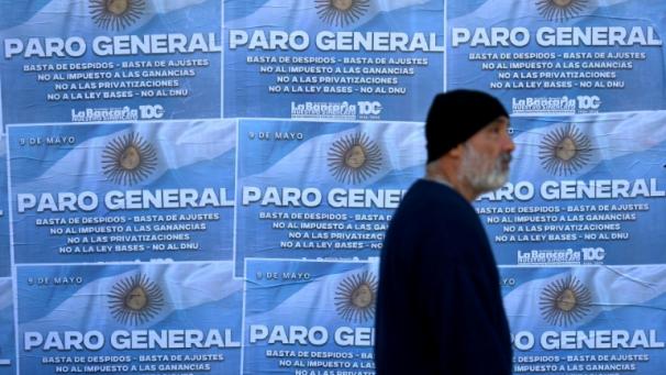 Un homme passe devant des affiches annonçant la grève général à Buenos Aires, le 9 mai 2024