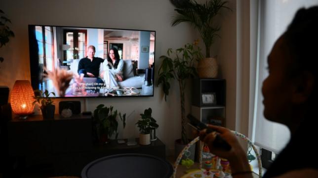 Une femme regarde un épisode de la série documentaire Harry & Meghan diffusée sur Netflix, le 8 décembre 2022 à Londres