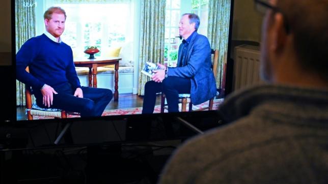Un téléspectateur à Manchester, au Royaume-Uni, regarde une interview du prince Harry sur la chaîne britannique ITV1, le 8 janvier 2023