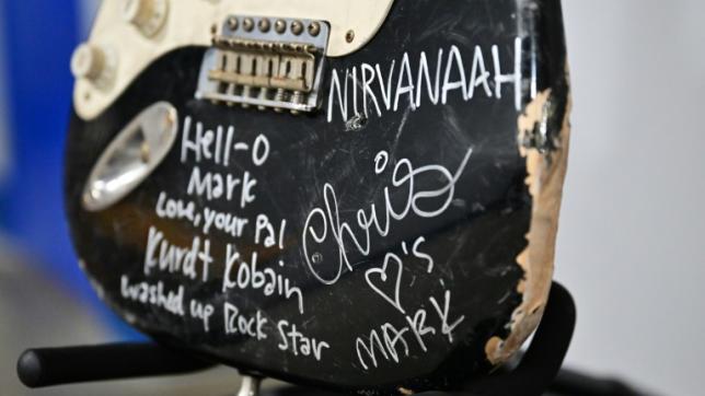 Une guitare Fender Stratocaster noire, fracassée sur scène par le chanteur Kurt Cobain, leader du groupe américain Nirvana, exposée chez Julien