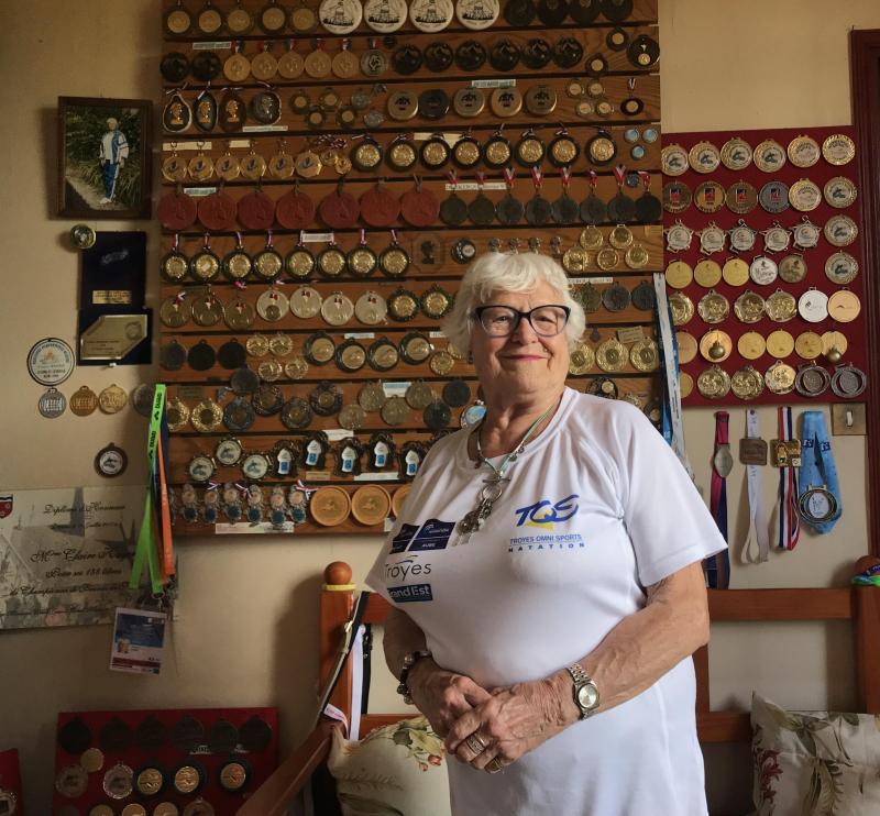 Claire Hager standing in front of some of her 206 gold medals. Palestinian Authority
