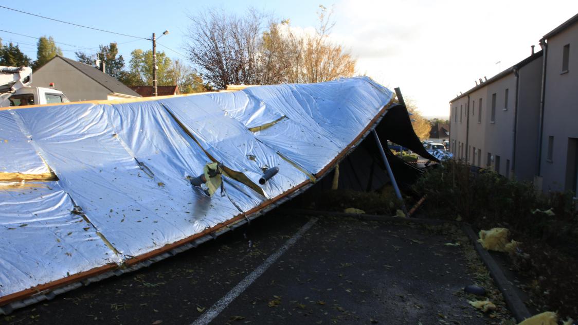 Le toit s’est immobilisé sur le parking de la résidence, recouvrant totalement ou partiellement trois véhicules.
