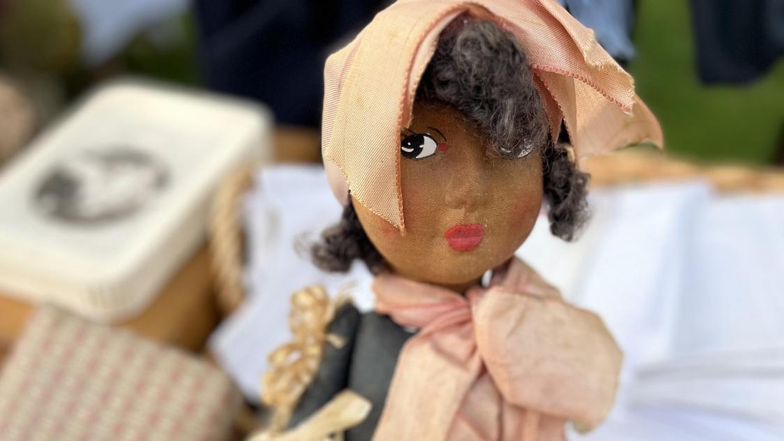 Sur le stand d’Evelyne, des Antiquités de la Cité : une poupée noire « des années 30 » au pagne en raphia.