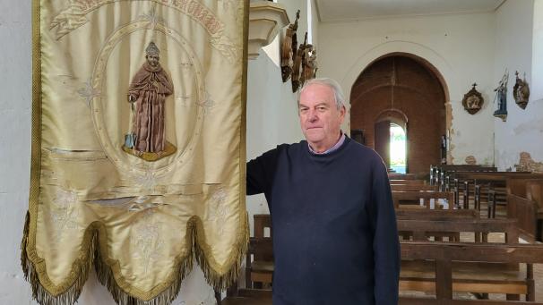 Christian Vanneau avec la bannière en l’honneur de Saint-Thiou dans l’église de Gronard.