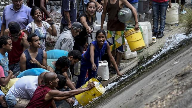 Confrontés à des pénuries, des Venezueliens récupèrent de l’eau dans un canal en mars dernier.