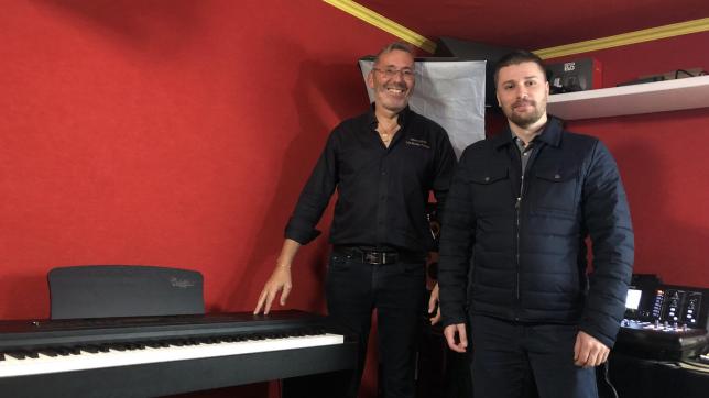 Olivier Colin et Raphaël Faber prennent la pose devant un piano Colmann.