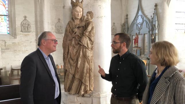 Devant la Vierge à l’enfant du XVe siècle, Rémy Marty (au centre), maire de Montaulin, discute de l’avenir des œuvres de son église avec Éric Blanchegorge, conservateur, en présence de Fantine Monot (Collectif Objets).
