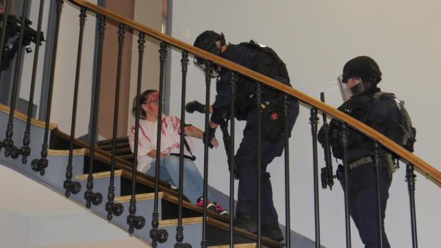 Les militaires du PSIG prennent en charge la dernière blessée dans les escaliers de la mairie.