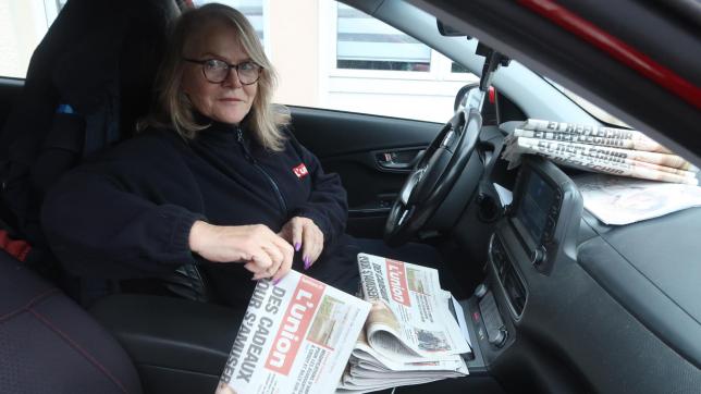 Sa voiture est son lieu de travail: les journaux sont disposés sur le siège passager, les magazines TV, aux pieds de ce même siège.