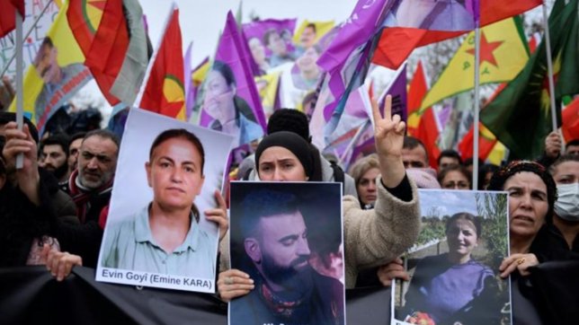 Des membres de la communauté kurde manifestent le 24 décembre 2022, au lendemain de l’attaque raciste dans le Xe arrondissement de Paris, avec des portraits de deux des victimes.