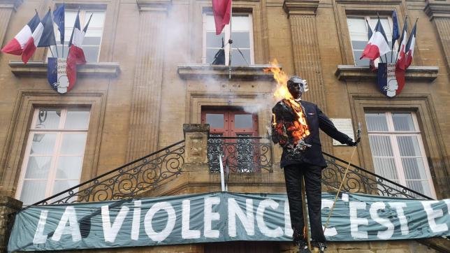 Les manifestants brûlent une marionnette à l’effigie d’un roi de France devant la mairie.