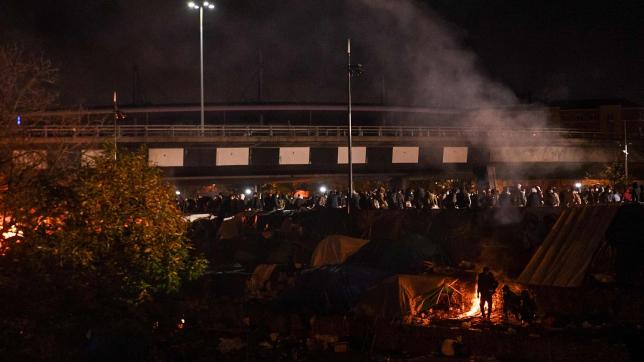 Des migrants avant l’évacuation par les forces de l’ordre de leur camp de fortune situé sous l'A1 dans la banlieue populaire de Saint-Denis, au nord de Paris, le 17 novembre 2020.